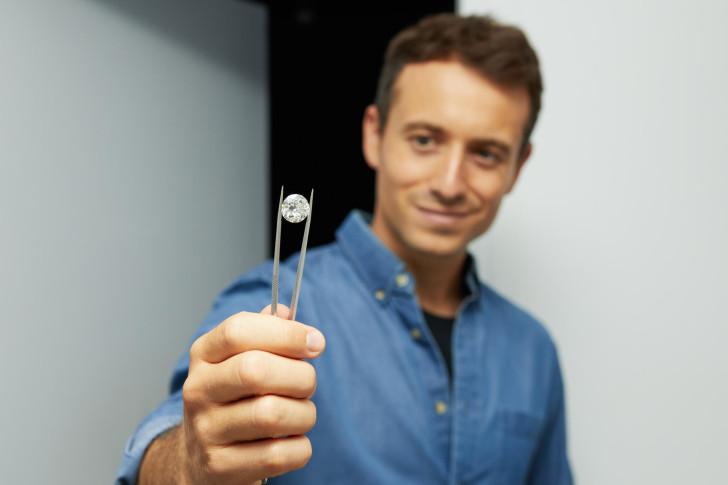 Hugo Clément présentant un diamant (tenu par une pince)